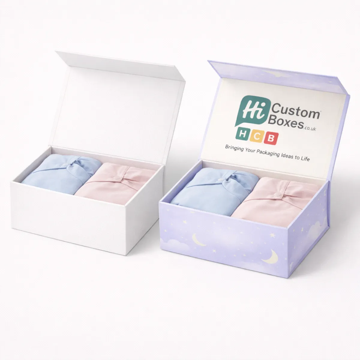 Two premium magnetic gift boxes containing folded blue and pink sleepwear garments side by side- class=